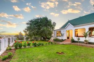 a white house with a yard at Ravenscliff Villa in Oudtshoorn