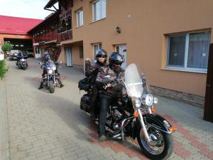 a group of people riding motorcycles down a street at Pensiunea Fábián Vendégház in Corund