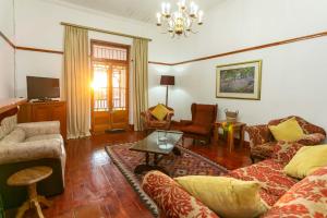 a living room with a couch and a table at Ravenscliff Villa in Oudtshoorn