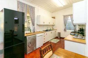 een keuken met een koelkast en een tafel. bij Ravenscliff Villa in Oudtshoorn