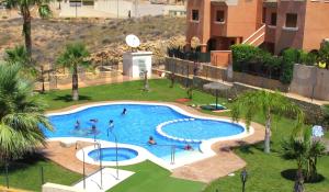 Una vista aérea de una piscina con gente en ella. en Sea view apartment with garden Mojon Hills, en Isla Plana