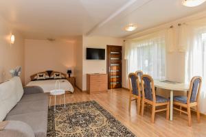a bedroom with a bed and a table and chairs at Apartamentų nuoma in Palanga