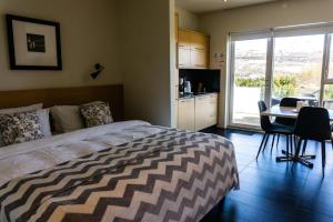 a bedroom with a bed and a table with chairs at Saeluhus Apartments & Houses in Akureyri