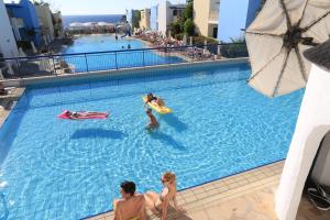 um grupo de pessoas brincando em uma piscina em Eleni Holiday Village em Pafos