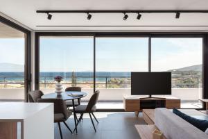 a living room with a tv and a large window at Sounio Panoramic Loft in Sounio