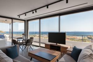 a living room with a couch and a flat screen tv at Sounio Panoramic Loft in Sounio