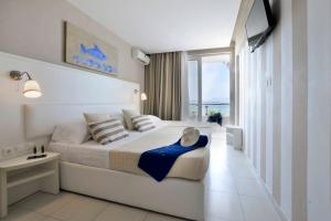 a bedroom with a bed with a view of the ocean at Sidari Beach Hotel in Sidari