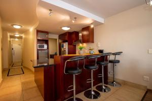 a kitchen with a bar with stools in it at Ocean View Luxury Self-Catering in Strand