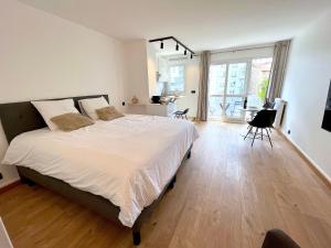 una camera con un grande letto e un pavimento in legno di le loft 56 de Boulogne a Boulogne-Billancourt