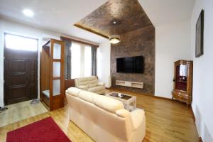 un soggiorno con divano e TV di Virág Apartman Luxury a Odorheiu Secuiesc