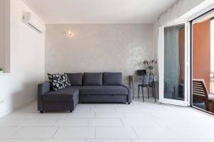ein Wohnzimmer mit einem Sofa und einem Fenster in der Unterkunft TERRAZZA SUL LAGO - Open Space e Netflix in Lecco