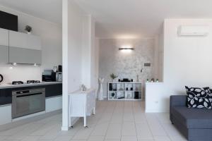 a white kitchen and living room with a couch at TERRAZZA SUL LAGO - Open Space e Netflix in Lecco