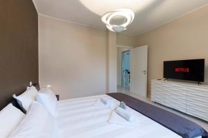 sypialnia z dużym łóżkiem z telewizorem w obiekcie TERRAZZA SUL LAGO - Open Space e Netflix w mieście Lecco