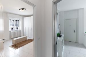 a white hallway with a door leading to a bathroom at TERRAZZA SUL LAGO - Open Space e Netflix in Lecco