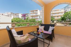 a patio with a table and chairs on a balcony at Apartments Villa Vujcic in Makarska