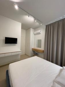 1 dormitorio con 1 cama y TV en la pared en Heaven Residence - Green Coast Resort, Palasë en Llogara