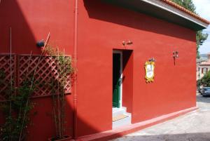 a red building with a door and a window at il Palazzo Rooms & Suites in Nafplio