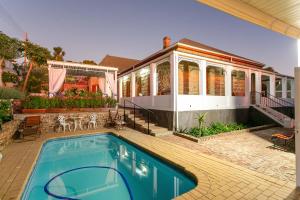 a house with a swimming pool in front of a house at Ravenscliff Manor in Oudtshoorn