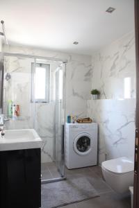 Un baño con lavadora y lavadora. en Edem Beach Apartment with Sea View by Athenian Homes, en Atenas