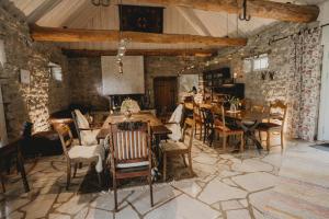 a dining room with tables and chairs and a stone wall at Muhu Tõnise Talu in Liiva