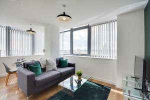 een woonkamer met een bank en een tafel bij City View Apartment in Liverpool