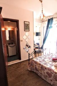 a bedroom with a bed and a desk and a window at B&B Antonella in Taormina