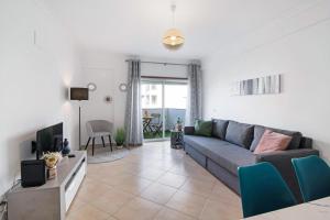 a living room with a couch and a tv at Apartamento Sunlight by Sunnyway in Albufeira