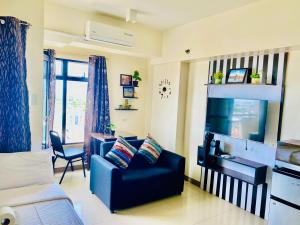 a living room with a couch and a tv at Mabolo Garden Flats Cebu in Cebu City