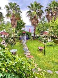 a garden with palm trees and a stone path at Peri Boutique Hotel in Sapanca