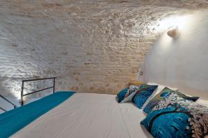 una camera con un letto in un muro di mattoni di AROMA luxury a Ostuni