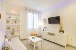 a living room with a couch and a tv and a table at Waterfront Apartment Parking in Marseille