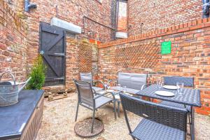 patio con mesa, sillas y pared de ladrillo en Spacious 5 Bed House, perfect for groups, great location, en Liverpool