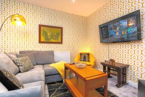 sala de estar con sofá y TV en la pared en Spacious 5 Bed House, perfect for groups, great location, en Liverpool