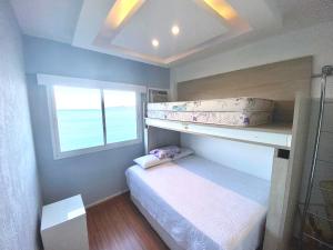a bedroom with two bunk beds and a window at Porto Real Suites Apto de frente p/mar in Mangaratiba