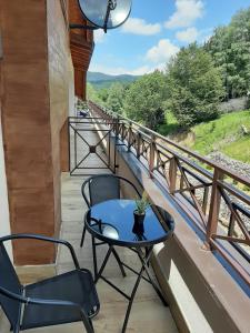 a patio with a table and chairs on a balcony at Milmari Apartman N92 Kopaonik in Kopaonik