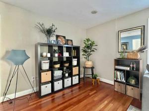a living room with a book shelf with boxes at Brand New, Cozy, Modern, One-bedroom Apartment in Falls Church