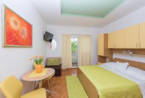 a hotel room with a bed and a table and chairs at Apartments Villa Vujcic in Makarska