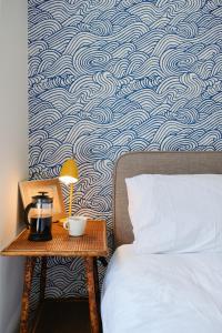 a bedroom with a bed and a table with a lamp at Finest Retreats - Primrose Cottage in Tywardreath