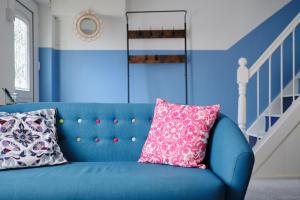 niebieska kanapa z dwoma poduszkami w pokoju w obiekcie Finest Retreats - Primrose Cottage w mieście Tywardreath