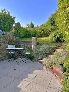 a picnic table and a bench in a garden at Finest Retreats - Primrose Cottage in Tywardreath