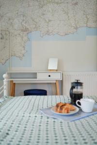 a plate of croissants and a cup of coffee on a bed at Finest Retreats - Primrose Cottage in Tywardreath +35 photos