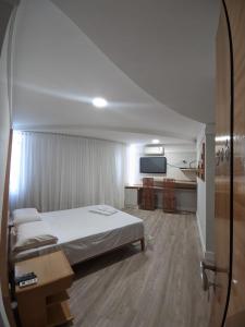 a hotel room with a bed and a tv at Horto Executivo Hotel in Ipatinga