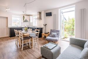 a kitchen and living room with a table and chairs at Rustics in Southwold