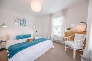 a bedroom with a large bed and a chair at Rustics in Southwold