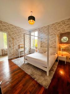a bedroom with a canopy bed and a rug at Villa avec vue et piscine à moins d'1h de Paris in Rolleboise