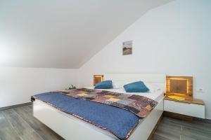 1 dormitorio con 1 cama blanca grande con almohadas azules en Apartments Amalija en Čilipi