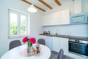 a kitchen with a table with flowers on it at Apartments Amalija in Čilipi