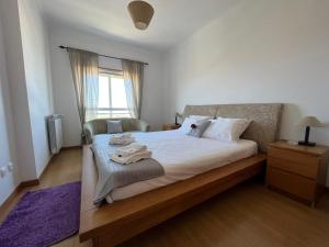 Schlafzimmer mit einem Bett mit weißer Bettwäsche und einem Fenster in der Unterkunft Amazing Lodge by the Ocean - Fully equipped! in Ericeira