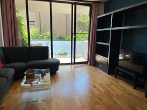 - un salon avec un canapé et une table en verre dans l'établissement Apartament 2 camere Nordului, à Bucarest