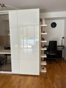 an office with a white partition with a desk and a chair at Apartament Lux 2 camere Nordului in Bucharest